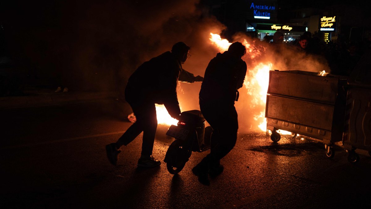 Rioters push a scooter into a barricade fire, Izmir, western Türkiye, March 21, 2025. (AFP Photo)