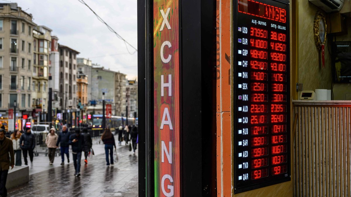 People walk past a currency exchange board in Istanbul, Türkiye, March 20, 2025. (AFP Photo)