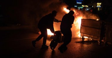 Rioters push a scooter into a barricade fire, Izmir, western Türkiye, March 21, 2025. (AFP Photo)