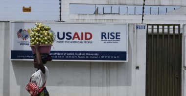 A Street vendor walks past the United States Agency for International Development (USAID) office, Abidjan, Cote d'Ivoire, March 22, 2025. (AFP Photo)