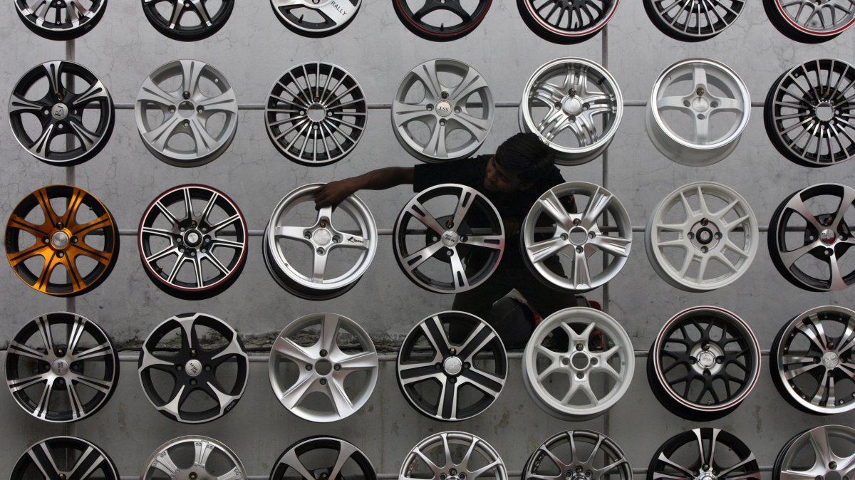 A worker displays alloy wheels for sale outside a car accessories shop, Hyderabad, southern India, Oct. 29, 2010. (Reuters Photo)