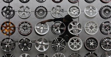 A worker displays alloy wheels for sale outside a car accessories shop, Hyderabad, southern India, Oct. 29, 2010. (Reuters Photo)