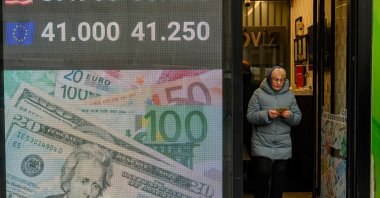 A woman exits a currency exchange, Istanbul, Türkiye, March 20, 2025. (AFP Photo)