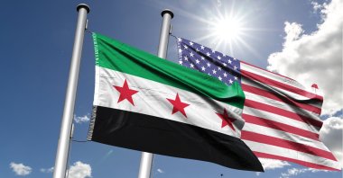The Syrian (L) and the U.S. flags fly under the sun. (Shutterstock Photo)