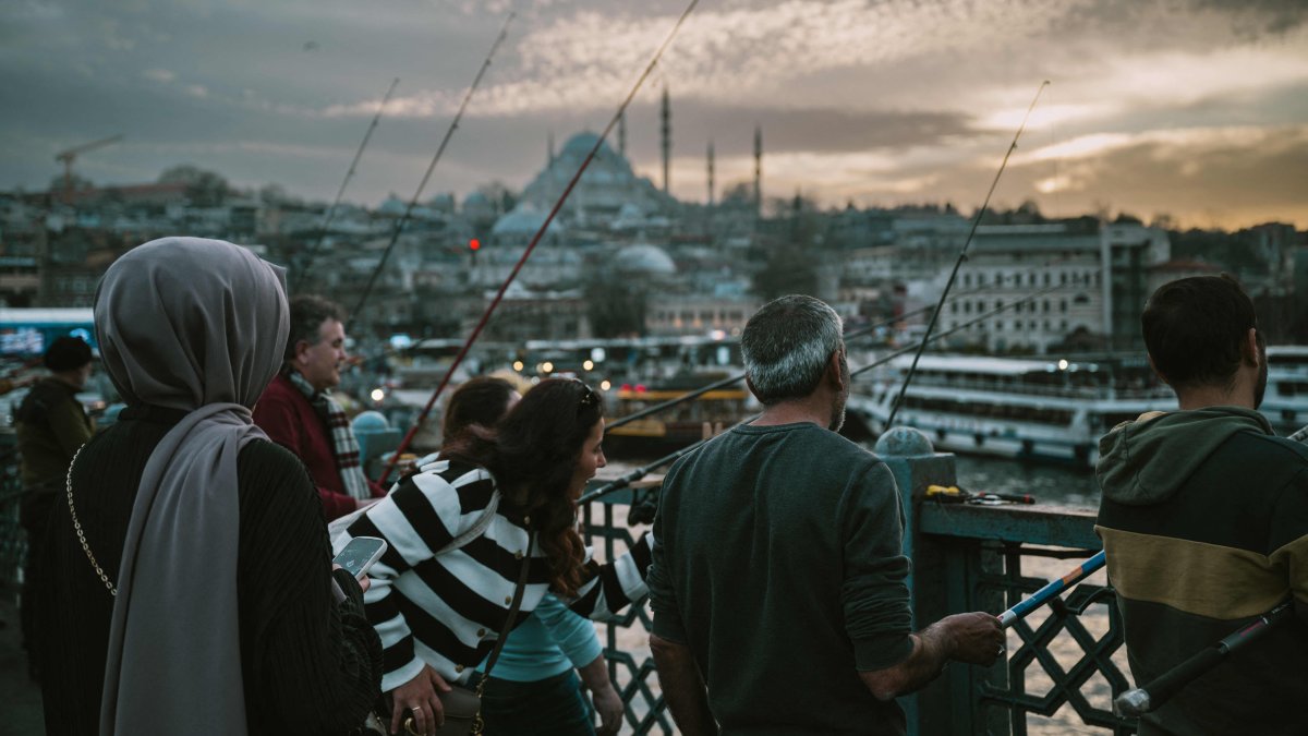 People fish on the historic Galata Bridge as the Süleymaniye mosque appears in the background, Istanbul, Türkiye, March 13, 2025. (AFP Photo)
