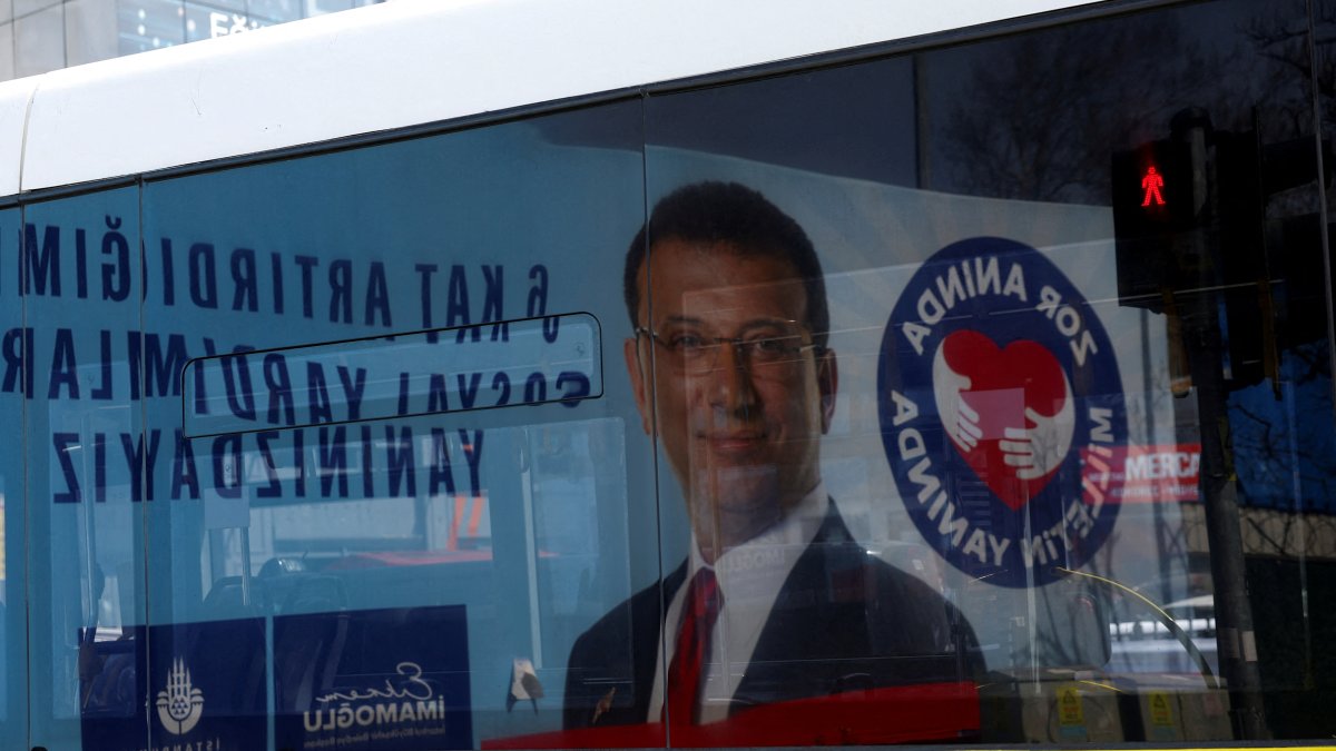 A billboard with a picture of Istanbul Mayor Ekrem Imamoğlu is reflected on a bus window the day he was jailed as part of a corruption investigation, Istanbul, Türkiye, March 23, 2025. (Reuters Photo)