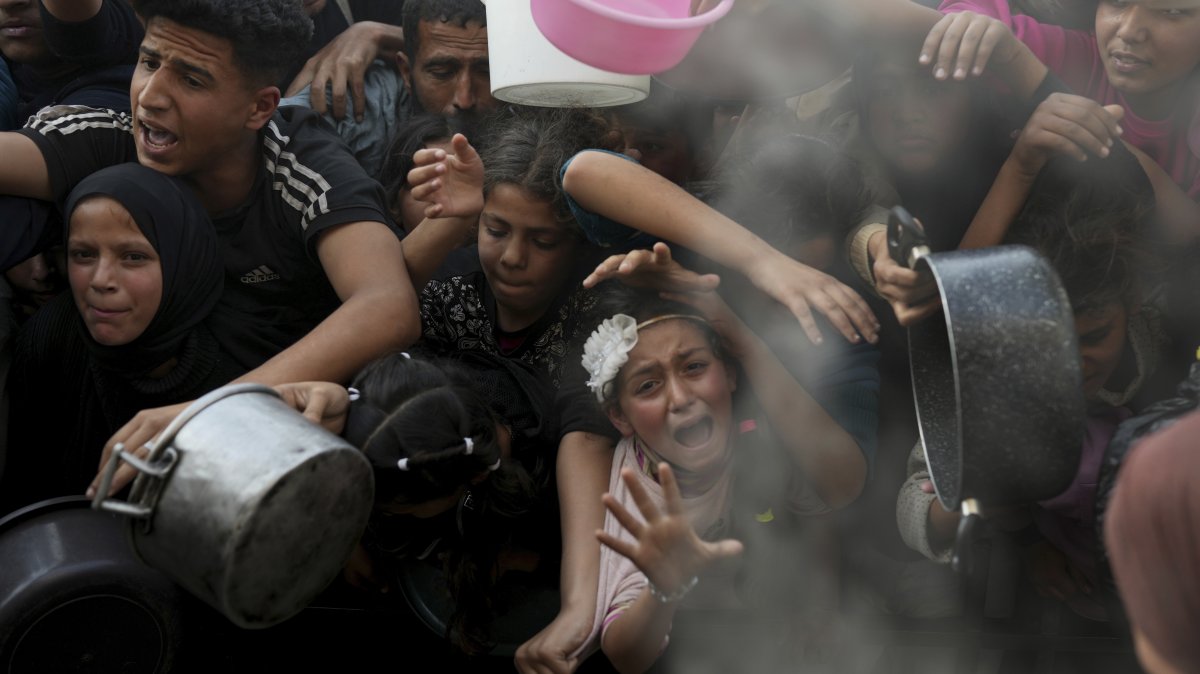A Palestinian girl struggles as she and others try to get donated food at a distribution center, Beit Lahiya, Gaza Strip, Palestine, March 16, 2025. (AP Photo)