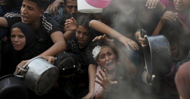 A Palestinian girl struggles as she and others try to get donated food at a distribution center, Beit Lahiya, Gaza Strip, Palestine, March 16, 2025. (AP Photo)
