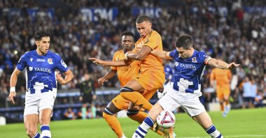 Real Sociedad's Igor Zubeldia (R) and Real Madrid's Kylian Mbappe (C) compete for the ball during a La Liga match at the Reale Arena, San Sebastian, Spain, Sept. 14, 2024. (AP Photo)