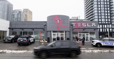 Pink spray paint is seen on the Tesla logo of the Tesla Service and Showroom centre after being spray painted by a protestor in Ottawa, Canada on Monday, March 31, 2025. (Spencer Colby/The Canadian Press via AP)