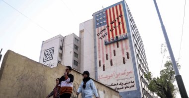 People walk by as a painter repaints an anti-U.S. mural, Tehran, Iran, March 29, 2025. (Reuters Photo)