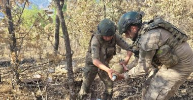 This photo taken in an undisclosed location shows soldiers examining munitions seized from PKK terrorists in northern Iraq, July 29, 2023. (AA Photo)