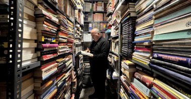 Faruk Yaman stands among his vast book collection in his home-turned-library, Kayseri, central Türkiye, March 31, 2025. (AA Photo)
