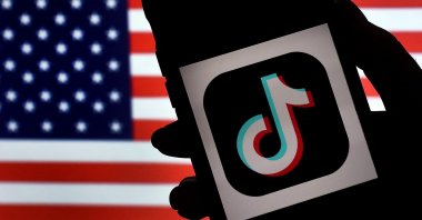  In this photo illustration, the social media application logo, TikTok is displayed on the screen of an iPhone on an American flag background, Aug. 3, 2020. (AFP File Photo)