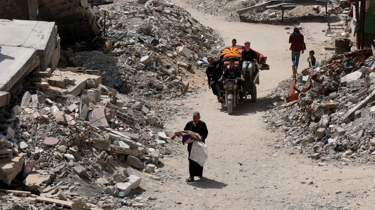 Palestinians move along a path near the rubble of houses, in Khan Younis in the southern Gaza Strip, Palestine, April 3, 2025. (Reuters Photo)
