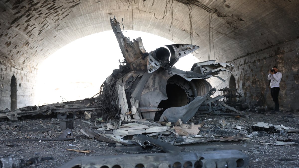 A man takes pictures of the destruction in a hangar after Israeli airstrikes targeted Hama military airport, April 3, 2025. (EPA Photo)