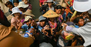People reach up for food aid being distributed in Sagaing, Myanmar, April 3, 2025. (AFP Photo)