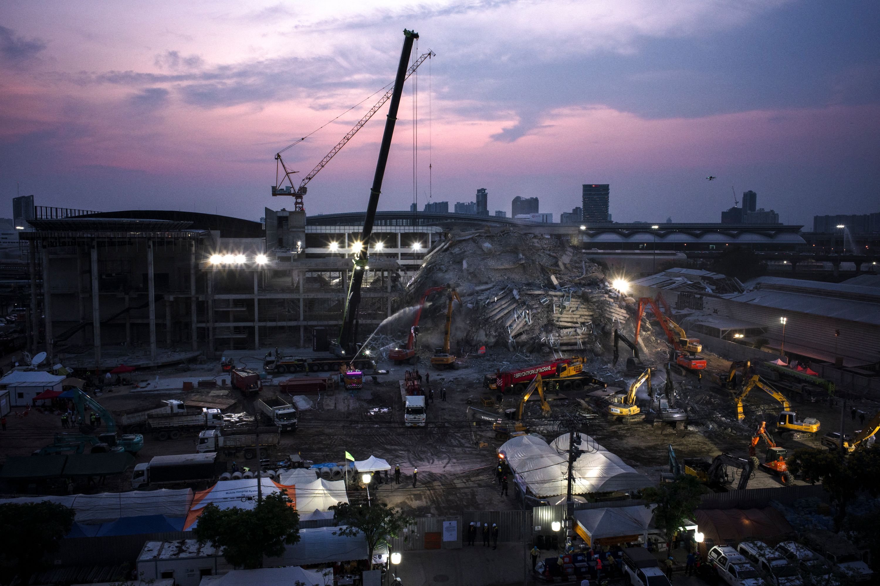 The sun sets over the site of an under-construction building collapse as rescue personnel work to find any survivors trapped in the rubble, Bangkok, Thailand, April 2, 2025. (AFP Photo)