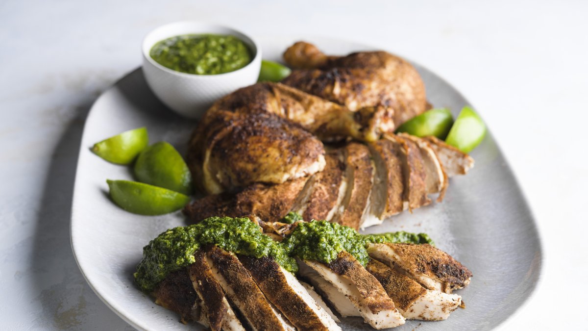 This image released by Milk Street shows a recipe for spice-rubbed roasted chicken with green-herb chutney. (AP Photo)