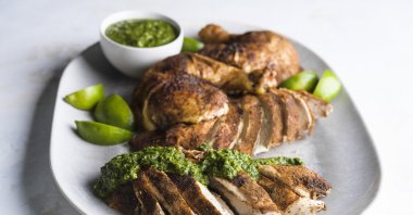 This image released by Milk Street shows a recipe for spice-rubbed roasted chicken with green-herb chutney. (AP Photo)