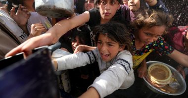 Palestinian children wait to receive food cooked by a charity kitchen, Beit Lahia, Gaza Strip, Palestine, April 3, 2025. (Reuters Photo)