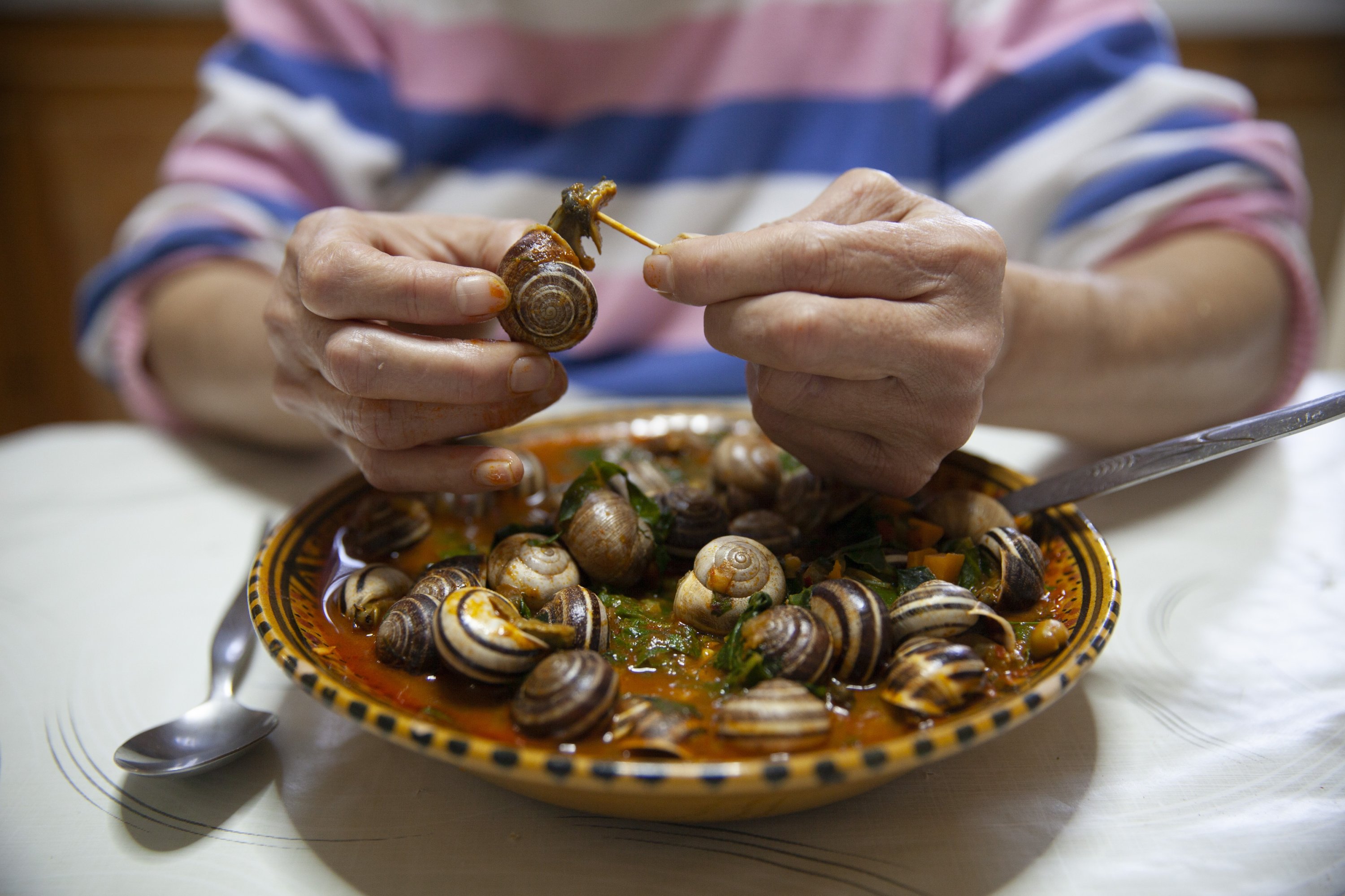 A Tunisian woman eats a meal of snails to break her Ramadan fast, Sfax, Tunisia, March 29, 2025. (AP Photo)