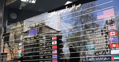 The American, EU and other flags are seen on a signboard at a currency exchange as the value of the Iranian rial drops, Tehran, Iran, March 26, 2025. (Reuters Photo)
