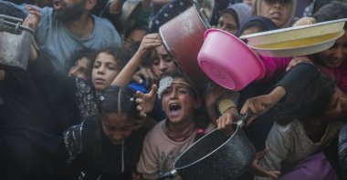 Palestinian children struggle while waiting for donated food at a distribution center, Beit Lahiya, Gaza Strip, Palestine, March 16, 2025. (AP Photo)