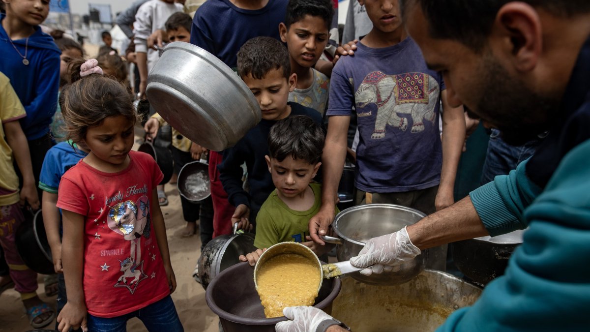 Internally displaced Palestinians gather to receive meals distributed by charities in the Jabalia refugee camp, northern Gaza Strip, April 8, 2025. (EPA Photo)