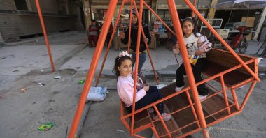 Children play in a swing as they celebrate the first day of Eid al-Fitr, marking the end of the holy Islamic month of Ramadan, the Yarmuk camp for Palestinian refugees, Damascus, Syria, March 31, 2025. (AFP)