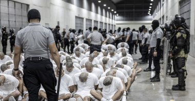 A prison guard transfers deportees from the U.S., alleged to be Venezuelan gang members, to the Terrorism Confinement Center in Tecoluca, El Salvador, March 16, 2025. (AP Photo)