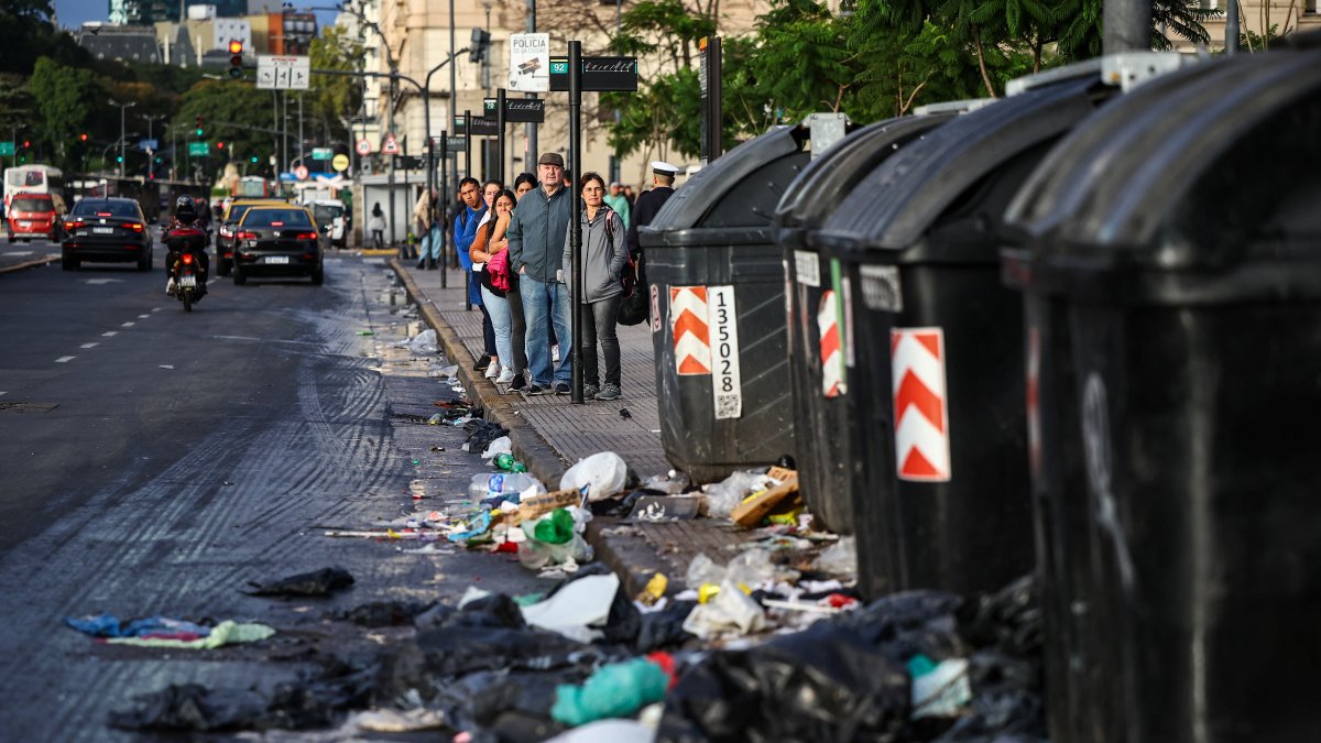 People stand at a bus stop near garbage on the ground, on the day of a 24-hour general strike against the adjustment policy of Argentinian President Javier Milei&#039;s government, in Buenos Aires, Argentina, April 10, 2025. (Reuters Photo)