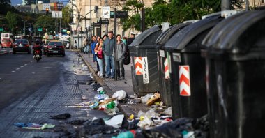 People stand at a bus stop near garbage on the ground, on the day of a 24-hour general strike against the adjustment policy of Argentinian President Javier Milei&#039;s government, in Buenos Aires, Argentina, April 10, 2025. (Reuters Photo)