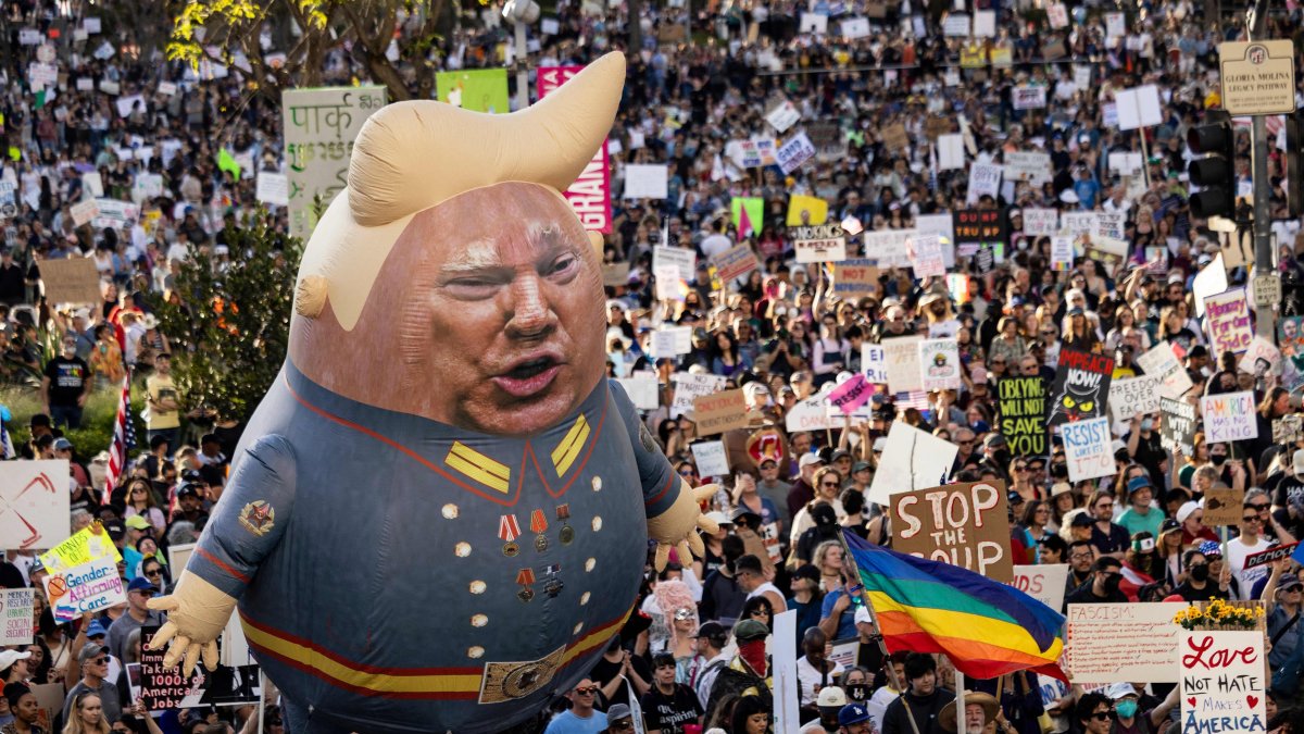 A large balloon with an image of U.S. President Donald Trump is seen above protesters holding signs during the nationwide "Hands Off!" protest against Trump and his advisor, Tesla CEO Elon Musk, in downtown Los Angeles on April 5, 2025. (AFP Photo)