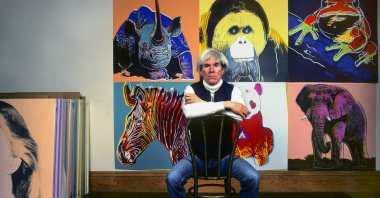 American pop artist Andy Warhol sits in front of several paintings in his &quot;Endangered Species&quot; series at his studio, the Factory, in Union Square, New York, U.S., April 12, 1983. (Getty Images Photo)