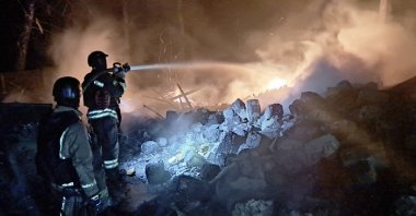 This handout photograph taken and released by Ukrainian State Emergency Service on March 28, 2025, shows firefighters manning a hose to put out a fire following a strike, Sumy region, Ukraine. (AFP Photo)