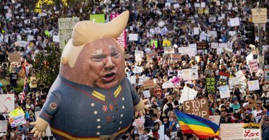 A large balloon with an image of U.S. President Donald Trump is seen above protesters holding signs during the nationwide "Hands Off!" protest against Trump and his advisor, Tesla CEO Elon Musk, in downtown Los Angeles on April 5, 2025. (AFP Photo)