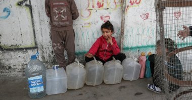 Palestinian children gather near containers used for water, Gaza City, Palestine, April 6, 2025. (Reuters Photo)