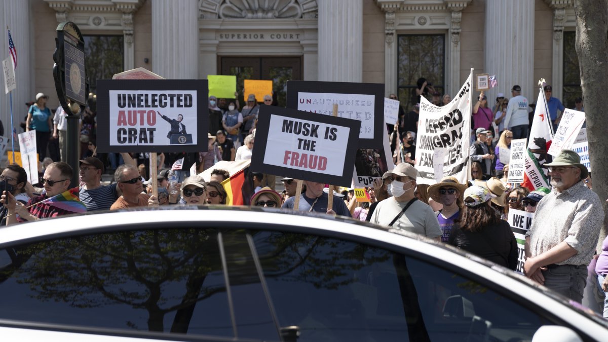 A Tesla vehicle drives past demonstrators during a rally against President Donald Trump and Tesla CEO Elon Musk as part of the nationwide &quot;Hands Off!&quot; protest, San Jose, California, U.S., April 5, 2025. (AP Photo)