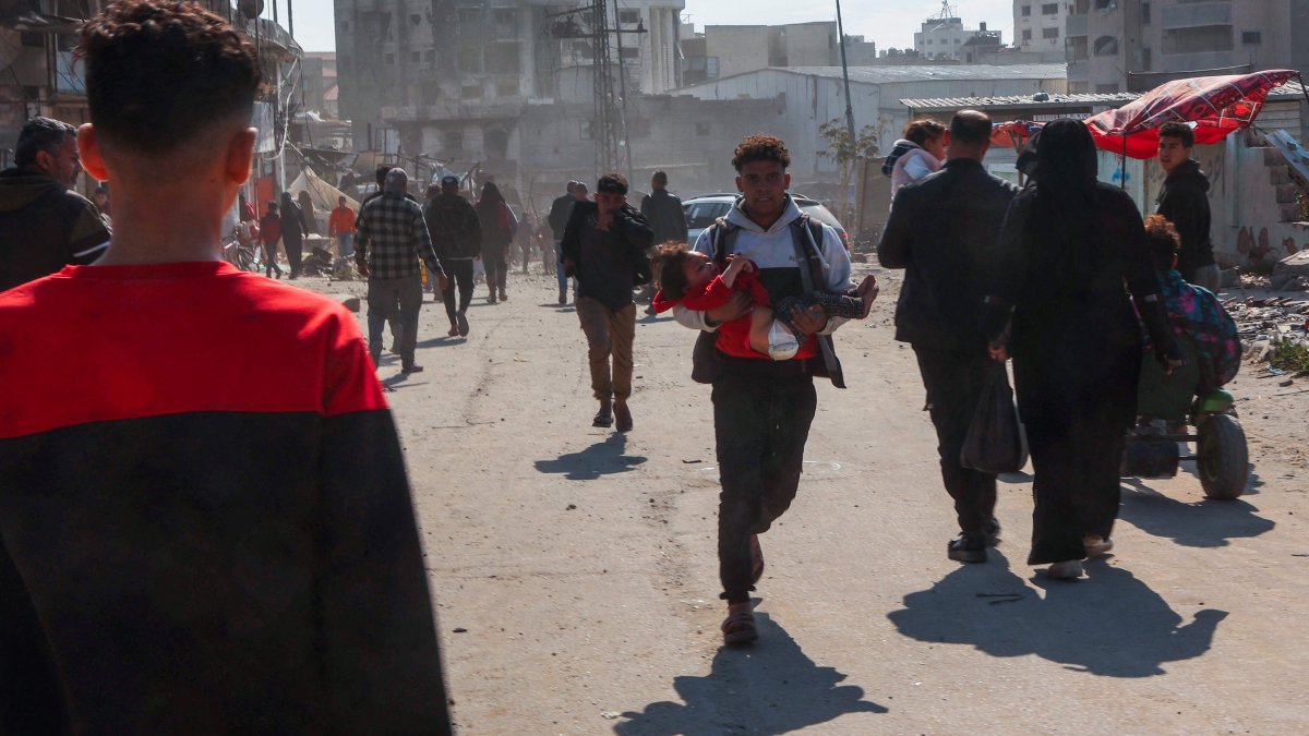 A Palestinian man rushes off carrying an injured girl following an Israeli strike on the Zaytoun neighborhood in Gaza City, central Gaza, Palestine, April 13, 2025. (AFP Photo)