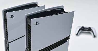 This photo illustration shows a Sony PlayStation 5 (L) and 5 Pro (C) on display at the Sony headquarters building in central Tokyo, Japan, Nov. 27, 2024. (AFP Photo)