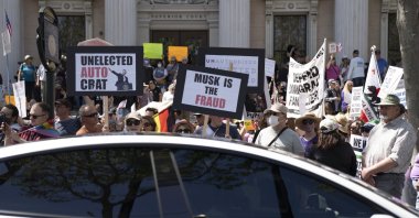 A Tesla vehicle drives past demonstrators during a rally against President Donald Trump and Tesla CEO Elon Musk as part of the nationwide &quot;Hands Off!&quot; protest, San Jose, California, U.S., April 5, 2025. (AP Photo)