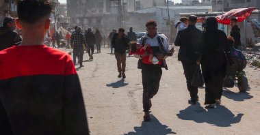 A Palestinian man rushes off carrying an injured girl following an Israeli strike on the Zaytoun neighborhood in Gaza City, central Gaza, Palestine, April 13, 2025. (AFP Photo)