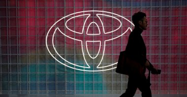 A man walks past a Toyota logo at the Tokyo Motor Show, Tokyo, Japan, Oct. 24, 2019. (Reuters Photo)