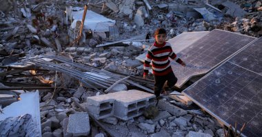 A boy walks past broken solar panels amidst rubble in Jabalia in the northern Gaza Strip, Palestine, April 14, 2025. (AFP Photo)
