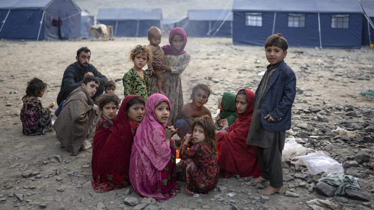 Afghan refugee children warm themselves with fire in a camp in Torkham, Afghanistan, Nov. 4, 2023. (AP Photo)