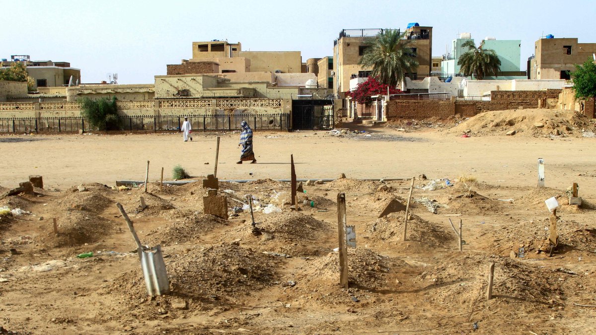 A Sudanese woman walks past graves of people killed during clashes lining the streets of Khartoum&#039;s twin-city Omdurman, Sudan, March 20, 2025. (AFP Photo)