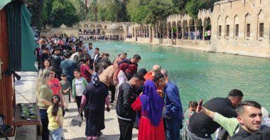 People enjoy and take photos of the sacred Balıklıgöl in Şanlıurfa, southeastern Türkiye, April 15, 2025. (AA Photo)