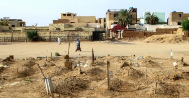 A Sudanese woman walks past graves of people killed during clashes lining the streets of Khartoum&#039;s twin-city Omdurman, Sudan, March 20, 2025. (AFP Photo)