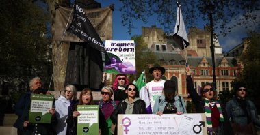 Activists sing as they hold placards including &quot;Women are born, not some bloke with a form&quot; and &quot;Women are women, men are men, you can&#039;t change sex with the stroke of a pen&quot; during a protest in Parliament Square across the Supreme Court in London, April 16, 2025. (AFP Photo)